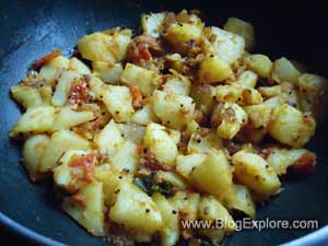 potatoes cooking with spices for potato tomato fry recipe