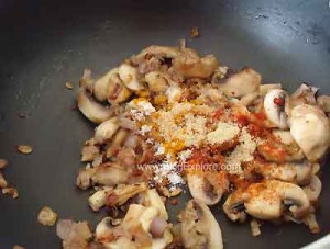 adding masalas for mushroom peas stir fry