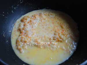 adding milk to coconut mixture for carrot coconut ladoo